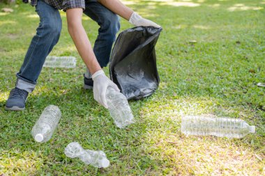 Çöp toplama, insanların elleri plastik şişeleri toplar, çöpleri parkları temizlemek, kirlilikten kaçınmak, çevreye ve ekosisteme dost olmak için siyah çöp torbalarına koyar..