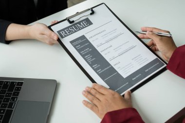 İş adamlarının bir özgeçmişi var ve iş görüşmeleri için iş başvurularıyla konuşuyorlar. Kariyerleri ve şirketteki kişisel geçmişleri hakkında. İşe alım kavramları.