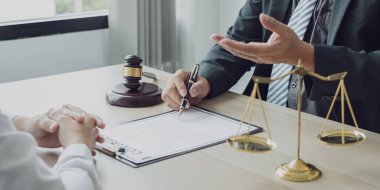 Bir erkek avukat ya da yargıç müvekkillerine adalet ve kovuşturma konusunda danışmanlık yapıyor. Teraziler, yargıç tokmağı, yasal belgeler, yasal hizmetler kavramı..