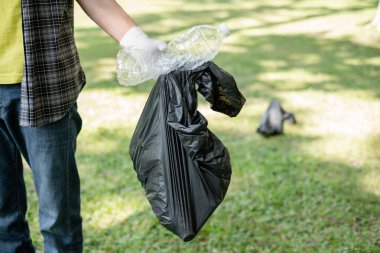 Çöp toplama, insanların elleri plastik şişeleri toplar, çöpleri parkları temizlemek, kirlilikten kaçınmak, çevreye ve ekosisteme dost olmak için siyah çöp torbalarına koyar..