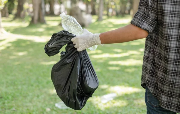 Çöp toplama, insanların elleri plastik şişeleri toplar, çöpleri parkları temizlemek, kirlilikten kaçınmak, çevreye ve ekosisteme dost olmak için siyah çöp torbalarına koyar..