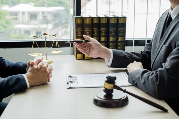 Male lawyers or a judge counseling clients about judicial justice and prosecution with scales, judges gavel, legal documents legal services concept.