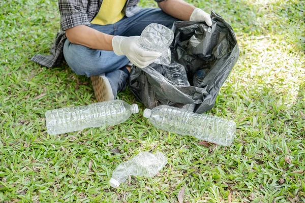 Çöp toplama, insanların elleri plastik şişeleri toplar, çöpleri parkları temizlemek, kirlilikten kaçınmak, çevreye ve ekosisteme dost olmak için siyah çöp torbalarına koyar..