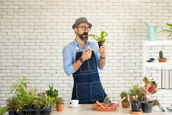 Bıyıklı, yaşlı ve yakışıklı bir adam ağaç bakımıyla mutlu olur. Evde bahçıvanlık hobisi. Emeklilikten sonra mutlu yaşamak. Doğa ve çevre kavramları.