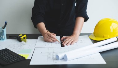 İnşaatta çalışan mimarlar ya da mühendisler inşaat planları, baskı, inşaat sahalarında yazılar çiziyor. Ev tasarımı kavramı.