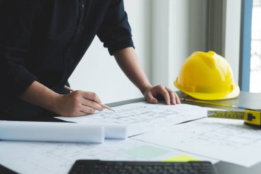 İnşaatta çalışan mimarlar ya da mühendisler inşaat planları, baskı, inşaat sahalarında yazılar çiziyor. Ev tasarımı kavramı.