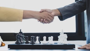 Satranç yarışmalarında satranç oynayan iki kişi liderlik, takipçiler ve stratejik planlar, iş başarısı oluşturma süreçleri ve takım çalışmalarını gösteriyor..