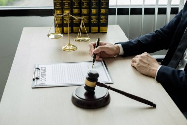 Profesyonel erkek avukatlar bir hukuk bürosunda çalışır. Teraziler, adalet terazileri, yargıç tokmağı ve dava belgeleri vardır. Hukuk ve adalet kavramları.