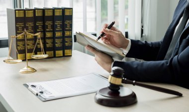 Profesyonel erkek avukatlar bir hukuk bürosunda çalışır. Teraziler, adalet terazileri, yargıç tokmağı ve dava belgeleri vardır. Hukuk ve adalet kavramları.