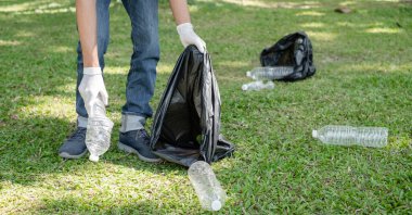 Adamın elleri plastik şişeleri topluyor, çöpleri siyah çöp torbalarına doldurup parkları temizliyor, kirlilikten kaçınıyor, çevreye ve ekosisteme dost oluyor..