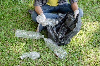Çöp toplama, insanların elleri plastik şişeleri toplar, çöpleri parkları temizlemek, kirlilikten kaçınmak, çevreye ve ekosisteme dost olmak için siyah çöp torbalarına koyar..