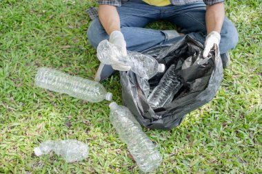 Adamın elleri plastik şişeleri topluyor, çöpleri siyah çöp torbalarına doldurup parkları temizliyor, kirlilikten kaçınıyor, çevreye ve ekosisteme dost oluyor..