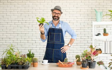 Bıyıklı, yaşlı ve yakışıklı bir adam ağaç bakımıyla mutlu olur. Evde bahçıvanlık hobisi. Emeklilikten sonra mutlu yaşamak. Doğa ve çevre kavramları.