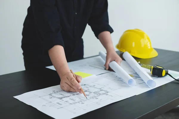 Architects or engineers working construction and drawing construction plans, printing, writing on-site construction sites. Home design concept.