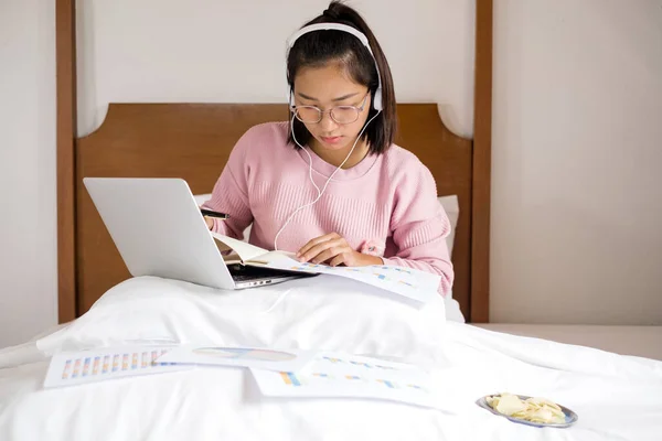 work from home, a young Asian woman who works in finance at home calculates financial graphs showing the results of his investments, planning the steps of his business growth.