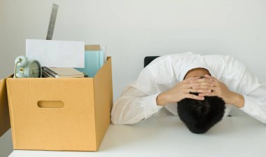 Bir erkek ofis çalışanı, karton kutulara bir şeyler dolduran bir şirketten kovulmaktan memnun değildir. Genç adam kovulduğu için stresliydi ve hayal kırıklığına uğradı. İşten çıkarma ve işsizlik kavramı.