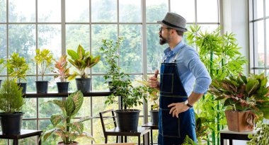 Bıyıklı, yaşlı ve yakışıklı bir adam ağaç bakımıyla mutlu olur. Evde bahçıvanlık hobisi. Emeklilikten sonra mutlu yaşamak. Doğa ve çevre kavramları.