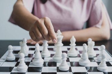 Hareket eden iş kadını eli, rekabetteki satranç liderlik, takipçiler ve ticari başarı stratejilerini gösteriyor.