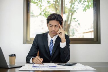 İş adamı veya finans piyasası analistleri, yatırım sonuçlarının başarılı iş büyümesi sürecini planladığını gösteren mali grafikler üzerinde çalışır ve hesaplarlar.