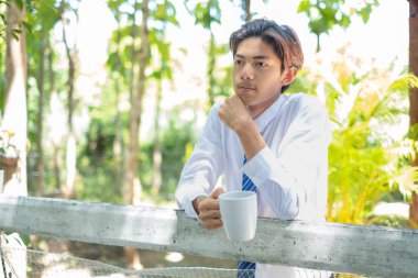 Asyalı iş adamı kahve içiyor, kahve molası veriyor ve fikirleri kullanıyor..