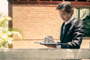 Gayrimenkul yatırımcısı ajanlar, müşterilerin, ev sahiplerinin ve ev sahiplerinin güvenliğini sağlamak için evlerini tutuyorlar. Ev ve gayrimenkul sigortası kavramları.