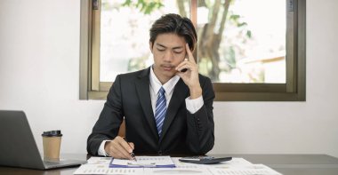 İş adamı veya finans piyasası analistleri, yatırım sonuçlarının başarılı iş büyümesi sürecini planladığını gösteren mali grafikler üzerinde çalışır ve hesaplarlar.