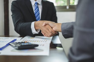 İş adamları toplantı başarıyla sonuçlandıktan sonra el sıkıştılar ve anlaştılar..