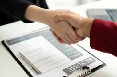 İşveren, iş başvurusunda bulunanlarla el sıkışıyor ve başarılı bir iş görüşmesi sonrasında yeni işe alınanları tebrik ediyor. İşe alım kavramları.