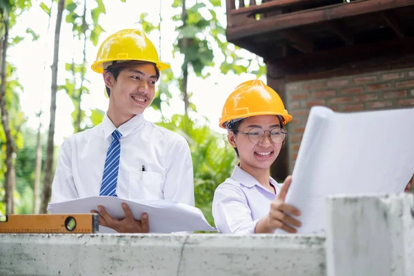 Team of male and female engineers and architects, working team, meeting, discussing construction, and inspecting the outdoor construction site work.