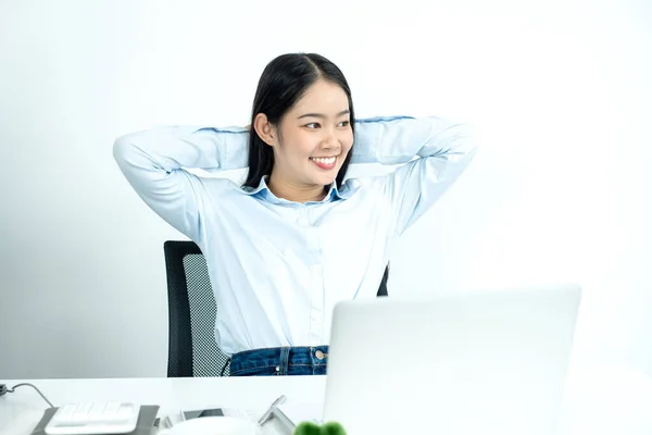 Asian female accountant is tired from working in a chair, stretching to relax and relax while working hard at the office.