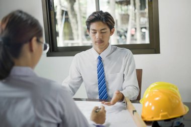 Erkek ve kadın mühendisler ve mimarlardan oluşan bir ekip, iş görüşmeleri, inşaat ve ev tasarımı projeleri hakkında tartışmalar. Ev tasarımı kavramı.