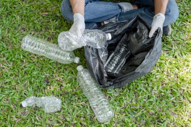 Çöp toplama, insanların elleri plastik şişeleri toplar, çöpleri parkları temizlemek, kirlilikten kaçınmak, çevreye ve ekosisteme dost olmak için siyah çöp torbalarına koyar..