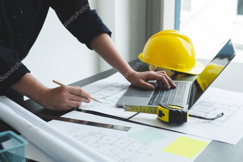 Architects or engineers working construction and drawing construction plans, printing, writing on-site construction sites. Home design concept.