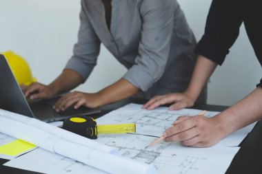 Mühendisler ve mimarlardan oluşan bir ekip, çalışma ekibi, toplantı, inşaat planları ve çizim planları, baskı, inşaat alanlarında yazma konuları. Ev tasarımı kavramı.