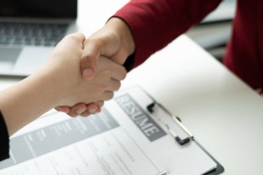 İşveren, iş başvurusunda bulunanlarla el sıkışıyor ve başarılı bir iş görüşmesi sonrasında yeni işe alınanları tebrik ediyor. İşe alım kavramları.