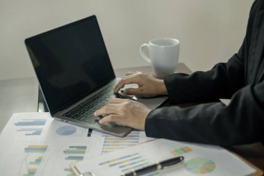 Asian female accountants sit at their desks and calculate financial graphs showing results about their investments, planning a successful business growth process.
