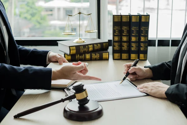 Male lawyers or a judge counseling clients about judicial justice and prosecution with scales, judges gavel, legal documents legal services concept.