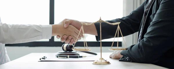 shake hand Professional man lawyers work at a law office There are scales, Scales of justice, judges gavel, and litigation documents. Concepts of law and justice.