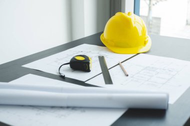 Mühendis ve mimar için güvenlik kaskı ve inşaat planları, baskı, inşaat alanlarında yazılar. Ev tasarımı kavramı.