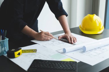 İnşaatta çalışan mimarlar ya da mühendisler inşaat planları, baskı, inşaat sahalarında yazılar çiziyor. Ev tasarımı kavramı.