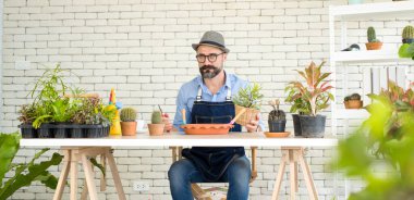 Bıyıklı, yaşlı ve yakışıklı bir adam ağaç bakımıyla mutlu olur. Evde bahçıvanlık hobisi. Emeklilikten sonra mutlu yaşamak. Doğa ve çevre kavramları.