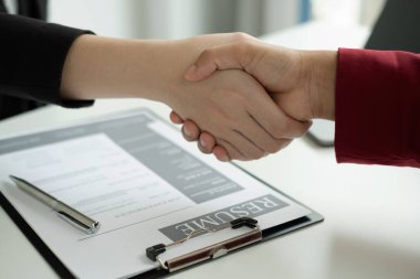İşveren, iş başvurusunda bulunanlarla el sıkışıyor ve başarılı bir iş görüşmesi sonrasında yeni işe alınanları tebrik ediyor. İşe alım kavramları.