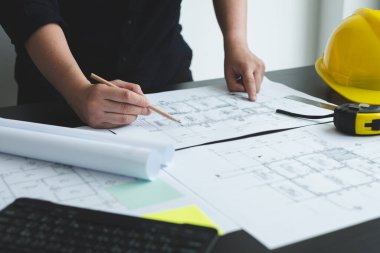 İnşaatta çalışan mimarlar ya da mühendisler inşaat planları, baskı, inşaat sahalarında yazılar çiziyor. Ev tasarımı kavramı.