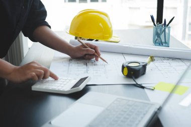 İnşaatta çalışan mimarlar ya da mühendisler inşaat planları, baskı, inşaat sahalarında yazılar çiziyor. Ev tasarımı kavramı.