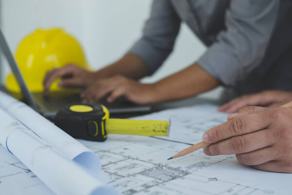 Team of engineers and architects, working team, meeting, discussing construction and drawing construction plans, printing, writing on-site construction sites. Home design concept.