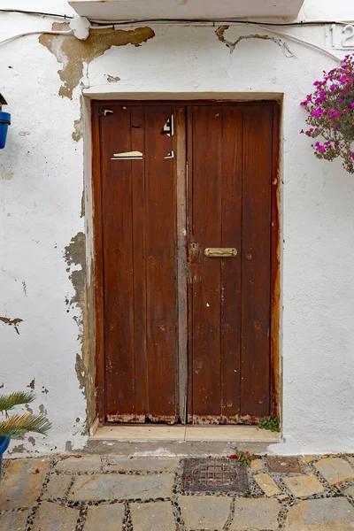 İspanya 'nın Estepona şehrinin arka sokaklarında, Costa del Sol' da eski ahşap bir kapı.