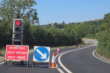 Somerset, İngiltere 'de trafik ışıkları tarafından kontrol edilen yol çalışmalarını bekliyor. Karşı yönden hiçbir trafik gelmiyor.