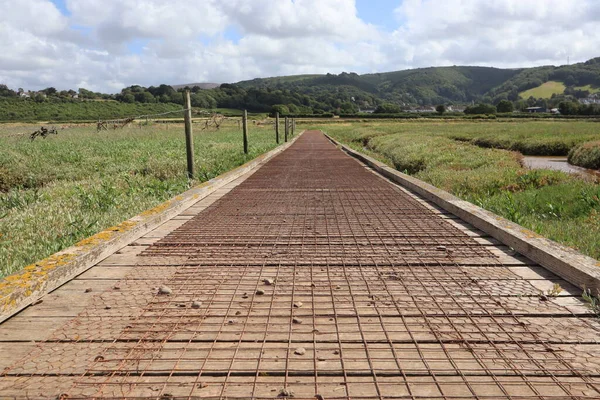 A low level view of a wooden walkway over Porlock salt marsh on the way back towards Bossington in Somerset, England