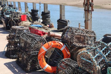 Lobster pots and other various pieces of fishing equipment piled up by the river Axe at Axmouth