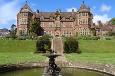 Bir çeşme ve iki kat taş merdiven güzel güneşli bir günde görkemli bir İngiliz evine çıkıyor.